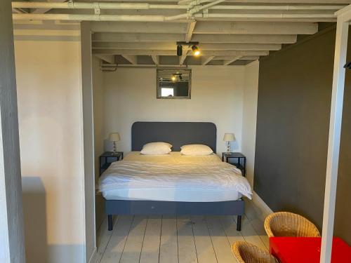 a bed in a room with two chairs in a room at Chateau Calon Segur in Durbuy