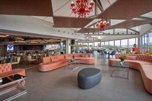 a lobby of a restaurant with pink couches and tables at Richmond Pamukkale Thermal in Pamukkale