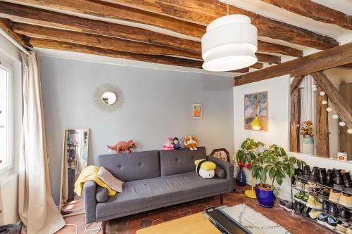 - un salon avec un canapé gris et des plafonds en bois dans l'établissement Nice And Bright 40 M For 2 Near Belleville, à Paris