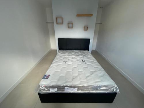 Cette chambre blanche comprend un grand lit avec un matelas. dans l'établissement Les embruns IV, à Saint-Jean-de-Monts