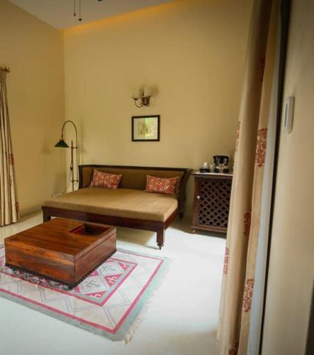 a living room with a couch and a coffee table at The Kipling Lodge- Nature Kalp in Khilchipur