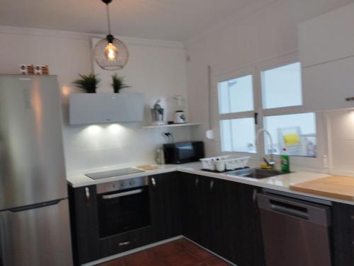 a kitchen with a refrigerator and a sink at Casa 35 Barrio El Charco Puerto del Rosario in Puerto del Rosario