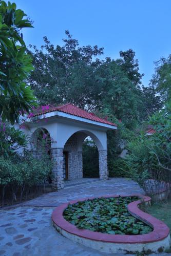 a garden with a stone arch and a pathway at The Kipling Lodge- Nature Kalp in Khilchipur
