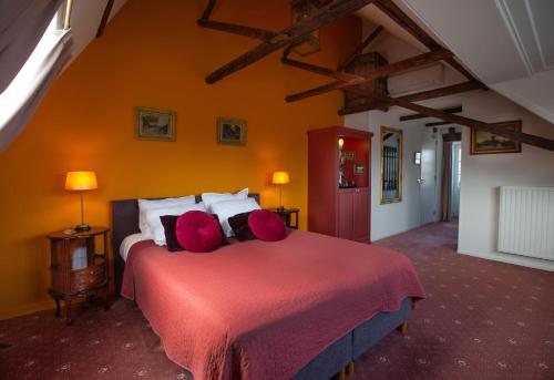 a bedroom with a large bed with a red blanket at Stadslogement De Oude Smidse Steenwijk in Steenwijk