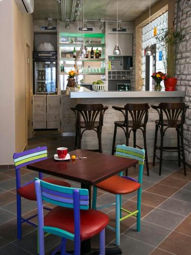a kitchen with a wooden table and chairs at Varad INN in Novi Sad