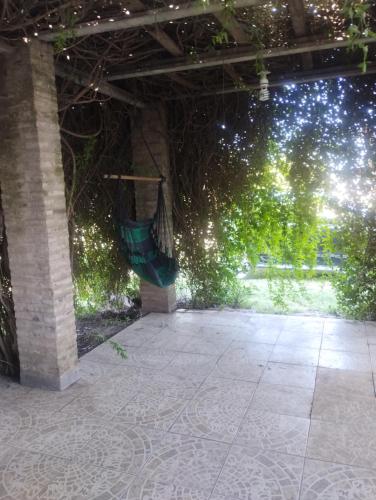 an outdoor patio with a green wall and trees at El portal in Pringles
