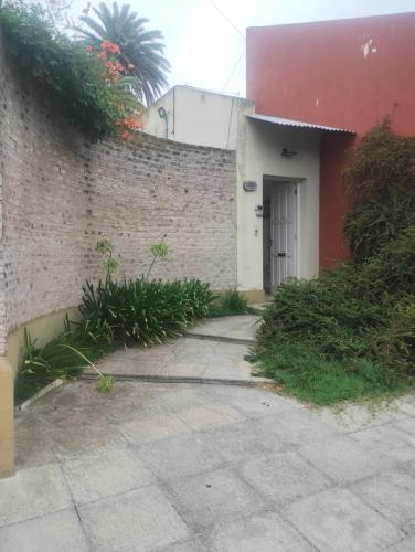 a brick building with a white door and a wall at El portal in Pringles