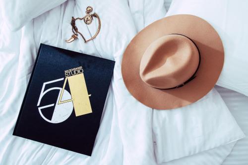 a person with a hat and a tag and a necklace at Schumacher Hotel Haifa in Haifa