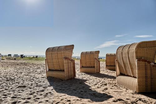a row of chairs sitting on the beach at Strandhotel Strande in Strande