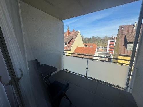 a balcony with a chair and a view of buildings at Hotel Barth in Kaiserslautern