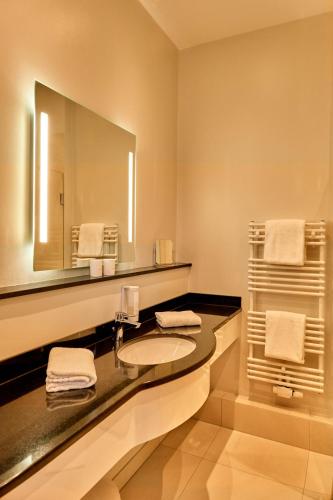 a bathroom with a sink and a large mirror at Strandhotel Strande in Strande