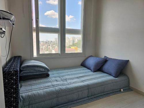 a couch sitting in a room with a window at 김포공항 강서구청 감성 뷰 하우스 in Seoul