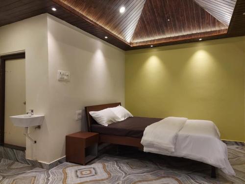 Postel nebo postele na pokoji v ubytování vasundhara agro hill resort
