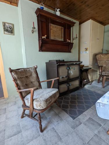 a living room with a chair and a stove at 2 Bedroom Cottage By Travel Lets Self Catering Accommodation Donegal With Sea View in Fanad
