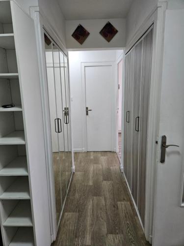 un couloir avec une porte et des étagères ainsi qu'une chambre dans l'établissement Appartement t3, à Saint-Étienne