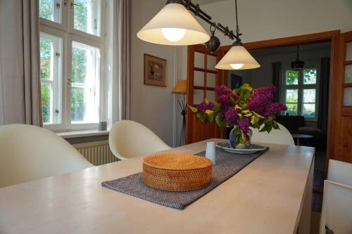 a dining room table with a vase of flowers on it at Jasmundhus in Neddesitz