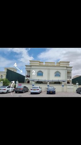Ḩayl Āl ‘Umayrにあるسكنات قصر الياسمينの前に車が駐車されている大きな建物