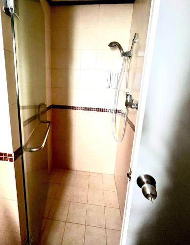 a shower in a bathroom with a tiled floor at Green Kuta Apartement in Seminyak