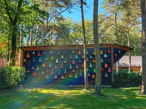 a colorful wall with books on it in a yard at Thuisje van Hout, tiny house in Drentse natuur in Zuidwolde