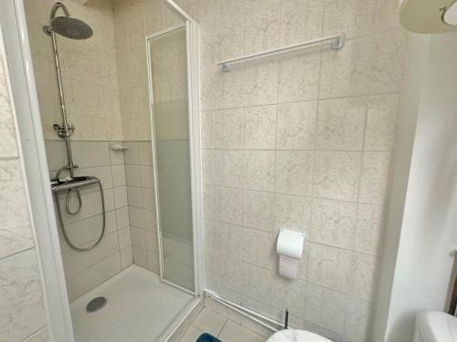 une salle de bain avec une douche avec une porte vitrée dans l'établissement Appartement - Cap d'Agde, au Cap d'Agde