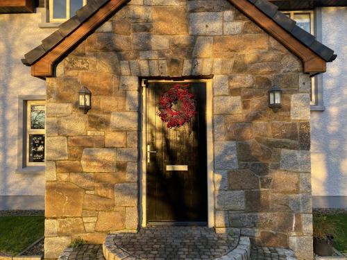 a building with a door with a wreath on it at Rostrevor Valley 5-Br Sleeps 10 w Hot Tub & View in Newry