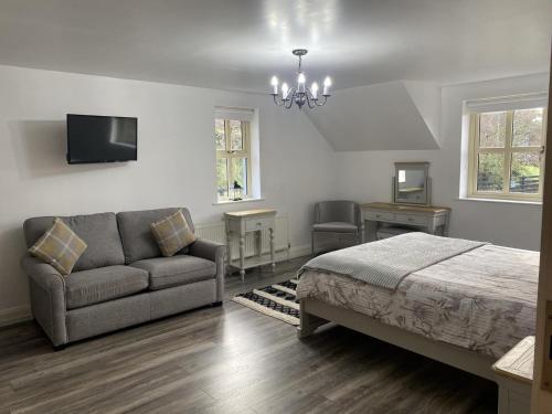 a bedroom with a bed and a couch and a tv at Rostrevor Valley 5-Br Sleeps 10 w Hot Tub & View in Newry