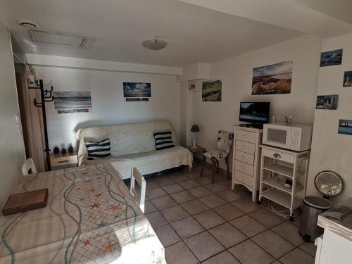 une chambre avec un lit et un bureau avec un micro-ondes dans l'établissement Studio au RDC d'une maison, à Quend-Plage