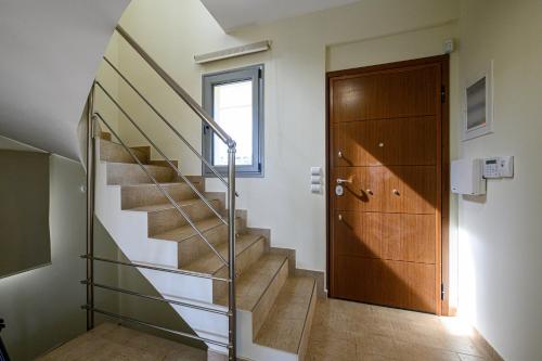 a staircase with a glass railing next to a door at Villa Olivia in Koroni