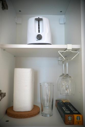 a shelf with a blender and a glass vase and a book at Ludovic Luxury Suite in Bucharest