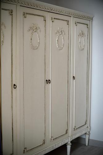 a white cabinet with gold decorations on it at Ludovic Luxury Suite in Bucharest