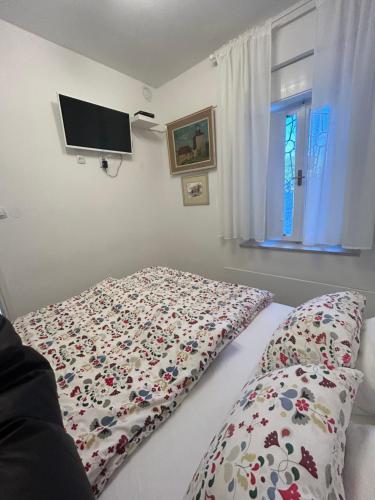 a bedroom with a bed with a flowered blanket on it at VERY CLOSE Studio Apartment in Zagreb