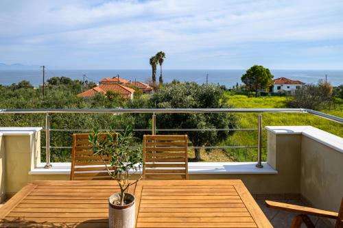 a porch with two chairs and a table on a balcony at Villa Olivia in Koroni