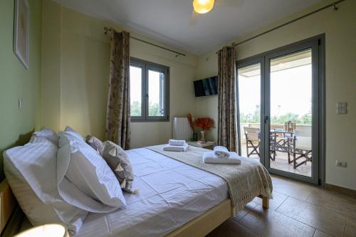 a bedroom with a bed and a balcony at Villa Olivia in Koroni