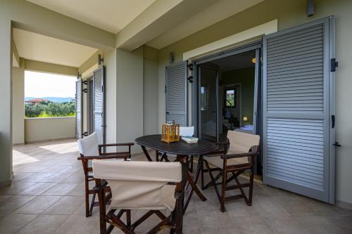 a dining room with a table and chairs on a patio at Villa Olivia in Koroni