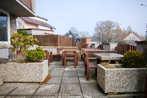 a patio with tables and chairs and a table and benches at Wellness Vila Bohemia in Prague