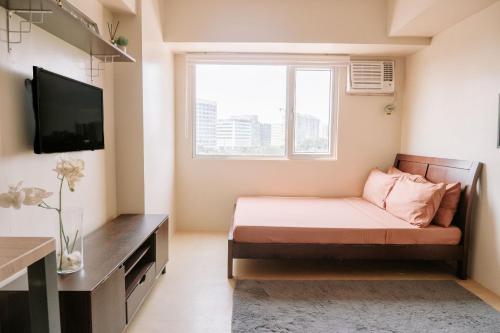 Habitación pequeña con sofá y TV. en A Dreamy Escape for Three, en Iloilo City
