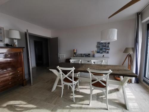 une salle à manger avec une table et des chaises en bois dans l'établissement La Plume Vue Mer Parking Privé, à Concarneau