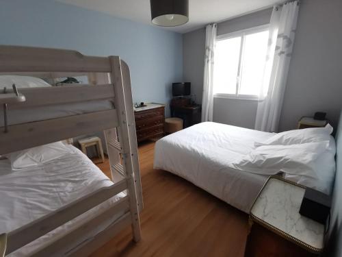 une chambre avec deux lits superposés et une fenêtre dans l'établissement La Plume Vue Mer Parking Privé, à Concarneau