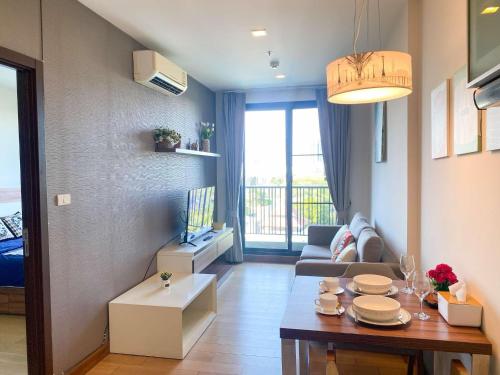 a living room with a couch and a table at The Astra Luxury Condo near old town in Chiang Mai