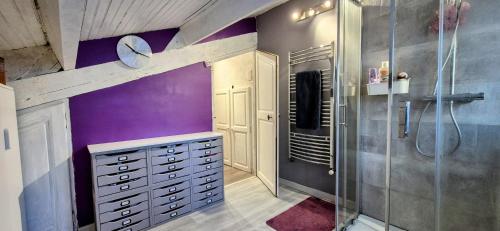 La salle de bains est pourvue de murs violets et d'une douche à l'italienne. dans l'établissement Villa Provençale Harmonie 8 Guest poolhouse, à Lambesc