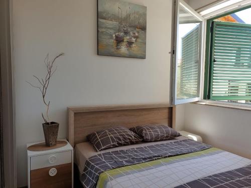 a small bedroom with a bed and a window at Victor Apartments in Petrovac na Moru