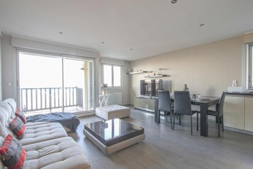 un salon avec un canapé et une table dans l'établissement Appartement face à la mer, à Cabourg