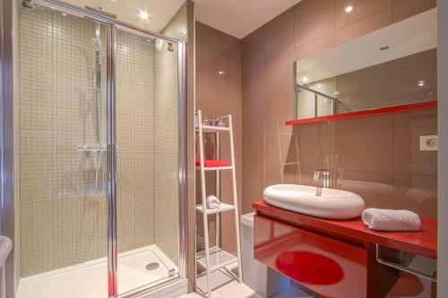 une salle de bain avec une douche en verre et un lavabo dans l'établissement Appartement face à la mer, à Cabourg