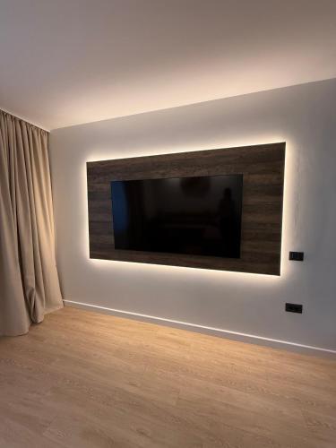 a flat screen tv on a wall in a room at Massif Carpathian Call in Poiana Brasov