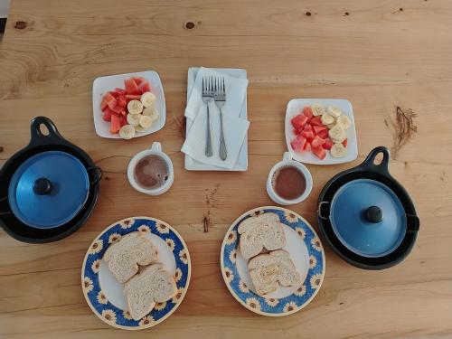 a table with plates of food and bowls of fruit at Villa Girasol in Villa de Leyva