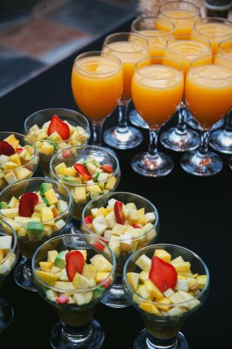 a table topped with bowls of fruit and glasses of orange juice at harmony surf lodge in Taghazout