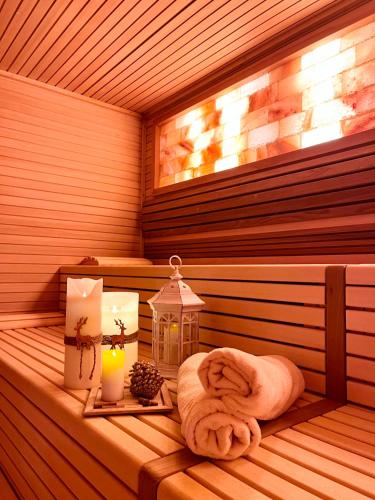 a sauna with a towel and candles and a lantern at Hotel Europa in San Martino di Castrozza
