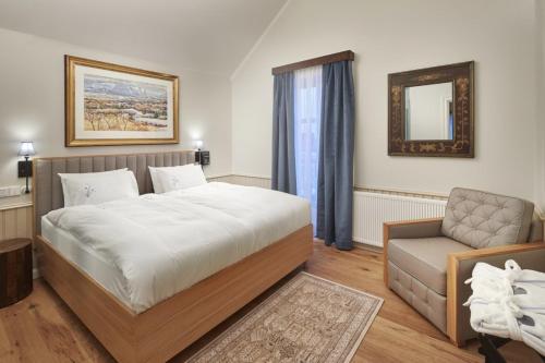 a bedroom with a bed and a chair and a mirror at Reykjavik Marina - Berjaya Iceland Hotels in Reykjavík