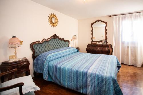 a bedroom with a bed with a blue comforter and a mirror at Dimora Zaira - Isola di Pellestrina Ve in Cavarzere