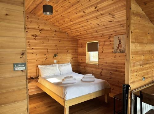 a bedroom with a bed in a wooden cabin at Lakeside Fishing Retreats in Boston